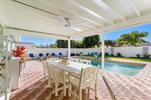 A covered patio with a pool, white furniture, and a ceiling fan. - 1258 Seminole Drive (Indian Harbour Beach)