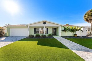 A single-story house with a garage, a well-maintained lawn, and a clear sky. - 1258 Seminole Drive (Indian Harbour Beach)
