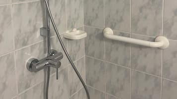A shower with a handheld showerhead, a handheld shower attachment, and a grab bar.