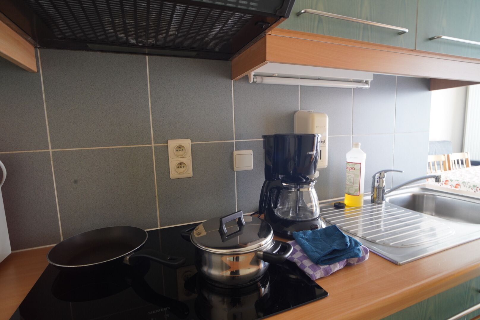 A kitchen with a coffee maker, a Siemens electric kettle, and a sink.