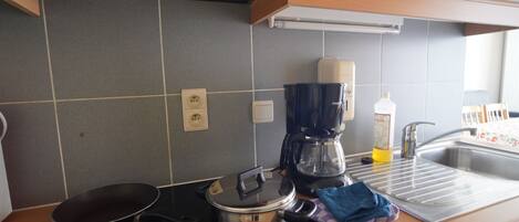 A kitchen with a coffee maker, a Siemens electric kettle, and a sink.