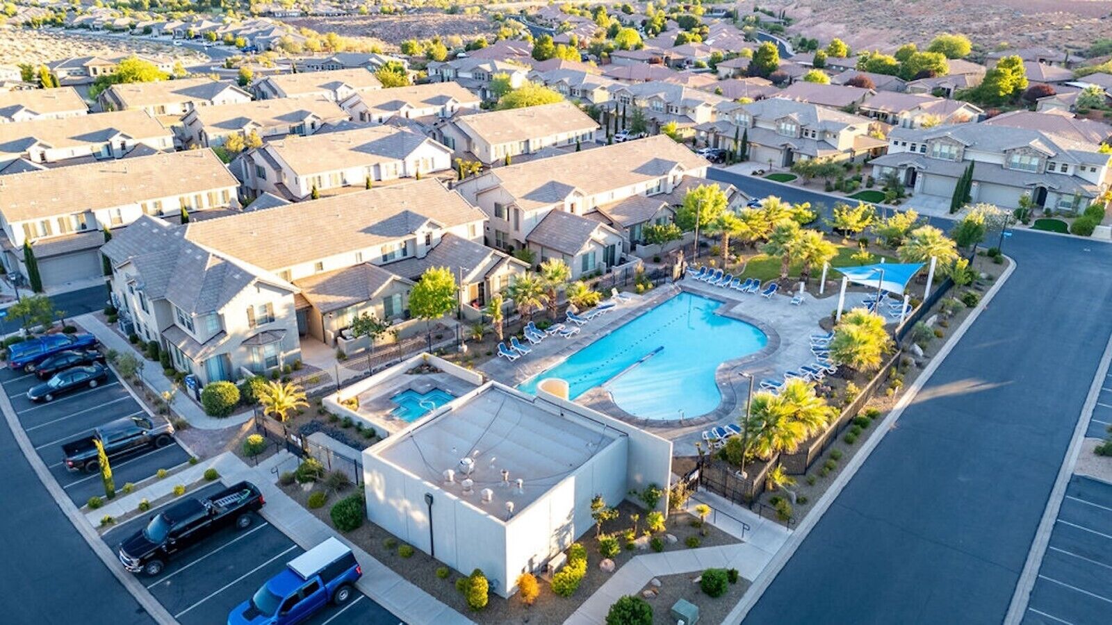 A residential area with multiple houses, a swimming pool, and a parking lot.