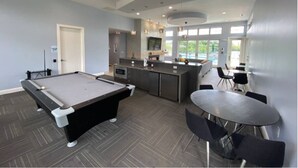 Quarto moderno com mesa de bilhar, bar e cozinha.