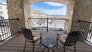 Un patio cubierto con paredes de piedra, dos sillas y una mesa.