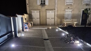 Ein Gebäude mit einem Schotterweg, einem Metalltor und einem Pfad, der zu einer Tür führt.
