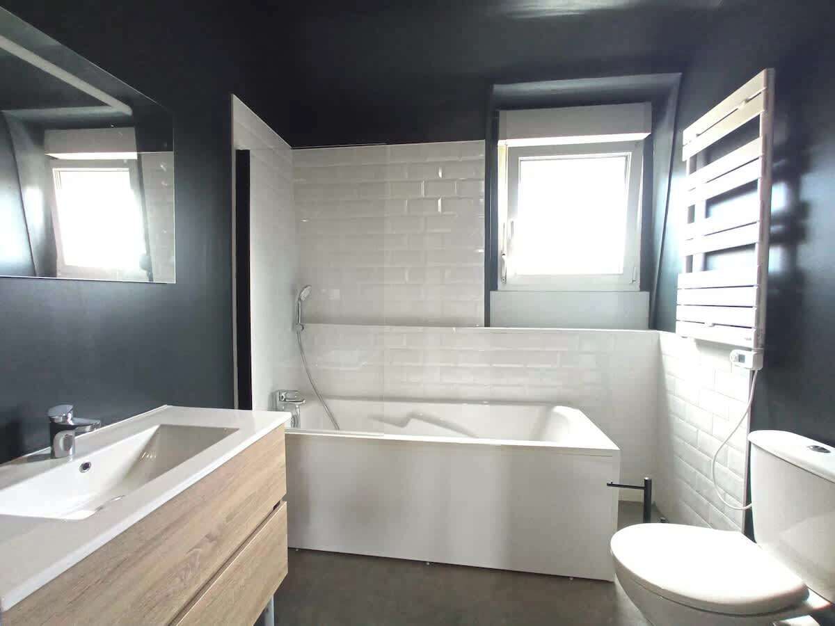 Un baño moderno con una bañera independiente, un lavabo y un inodoro.