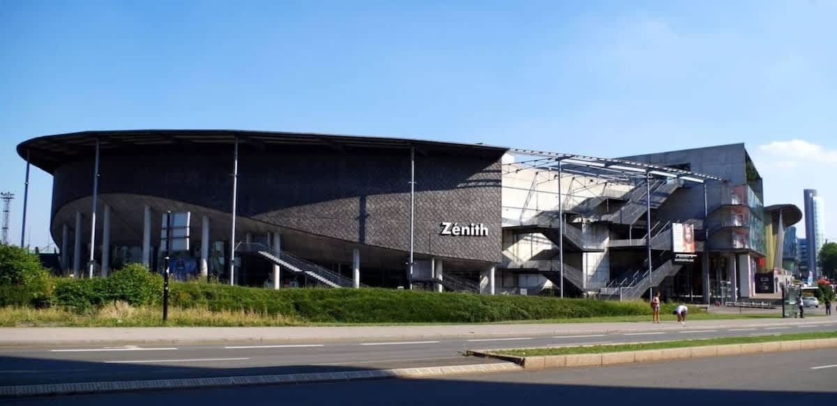 En moderne bygning med et buet tag og navnet 'Zénith' på facaden.