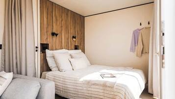 Una camera da letto moderna con un letto, un divano e una parete d'accento in legno.