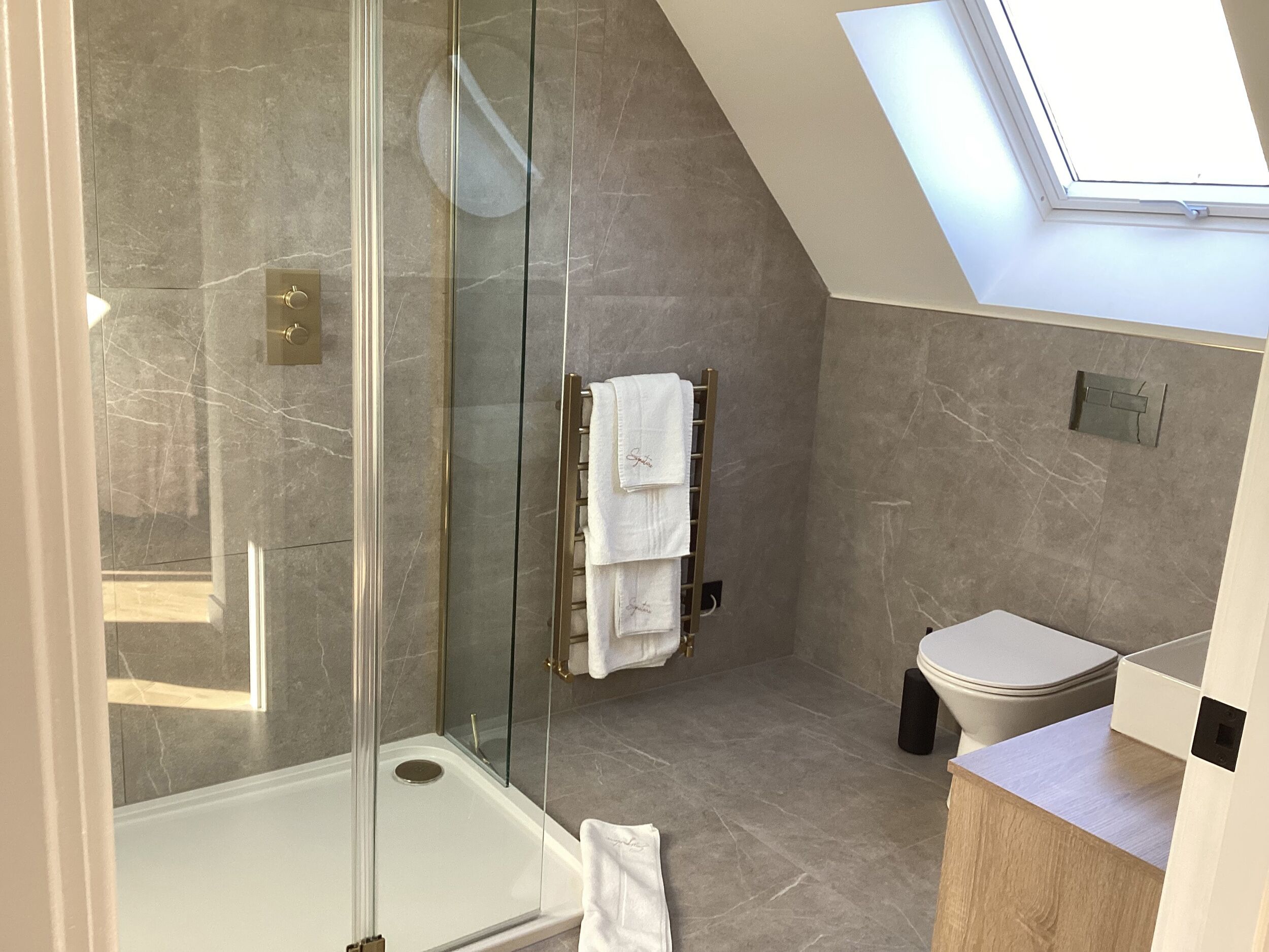 Une salle de bain moderne avec une douche à parois de verre, des toilettes et un meuble-lavabo.