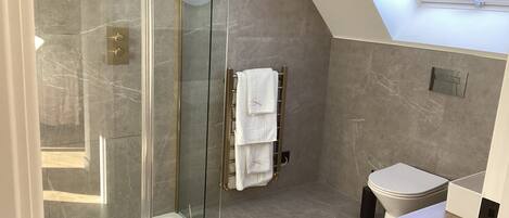 Une salle de bain moderne avec une douche à parois de verre, des toilettes et un meuble-lavabo.