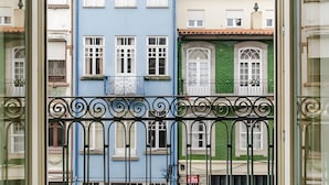 Una hilera de edificios coloridos con estilos arquitectónicos variados, incluyendo un edificio azul con ventanas blancas y uno verde con fachada de ladrillo.