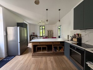 Una cocina moderna con una isla grande, horno empotrado y refrigerador.