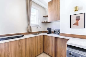 Eine moderne Küche mit Holzausstattung, einem Einbauofen und einer Kaffeemaschine.