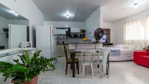 Um espaço compacto com cozinha compacta, área de refeições e quarto.