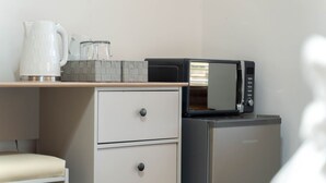 A compact kitchenette with a microwave, a kettle, and a small refrigerator. - Ben View Room & Jacuzzi Bath (Fort William)