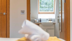 A bathroom with a wooden door, a window, a sink, and toiletries. - Ben View Room 2 in Fort William (Fort William)