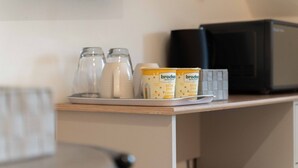 A kitchen counter with a microwave, two glass containers, and two jars of Brocham Golden Syrup on a tray. - Ben View Room 2 in Fort William (Fort William)