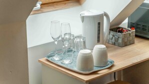 A tray with glasses and plates on a wooden table in a room with a skylight and a kettle. - Ben View Room 3 in Fort William (Fort William)