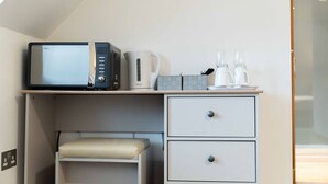 A compact kitchenette with a microwave, coffee maker, and two kettles on a white countertop. - Ben View Room 4 in Fort William (Fort William)