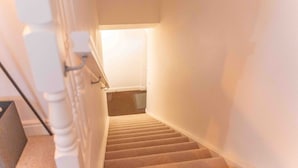 A staircase with a handrail and a light fixture at the top.