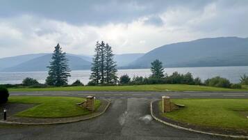 A road leading to a body of water with mountains in the background.