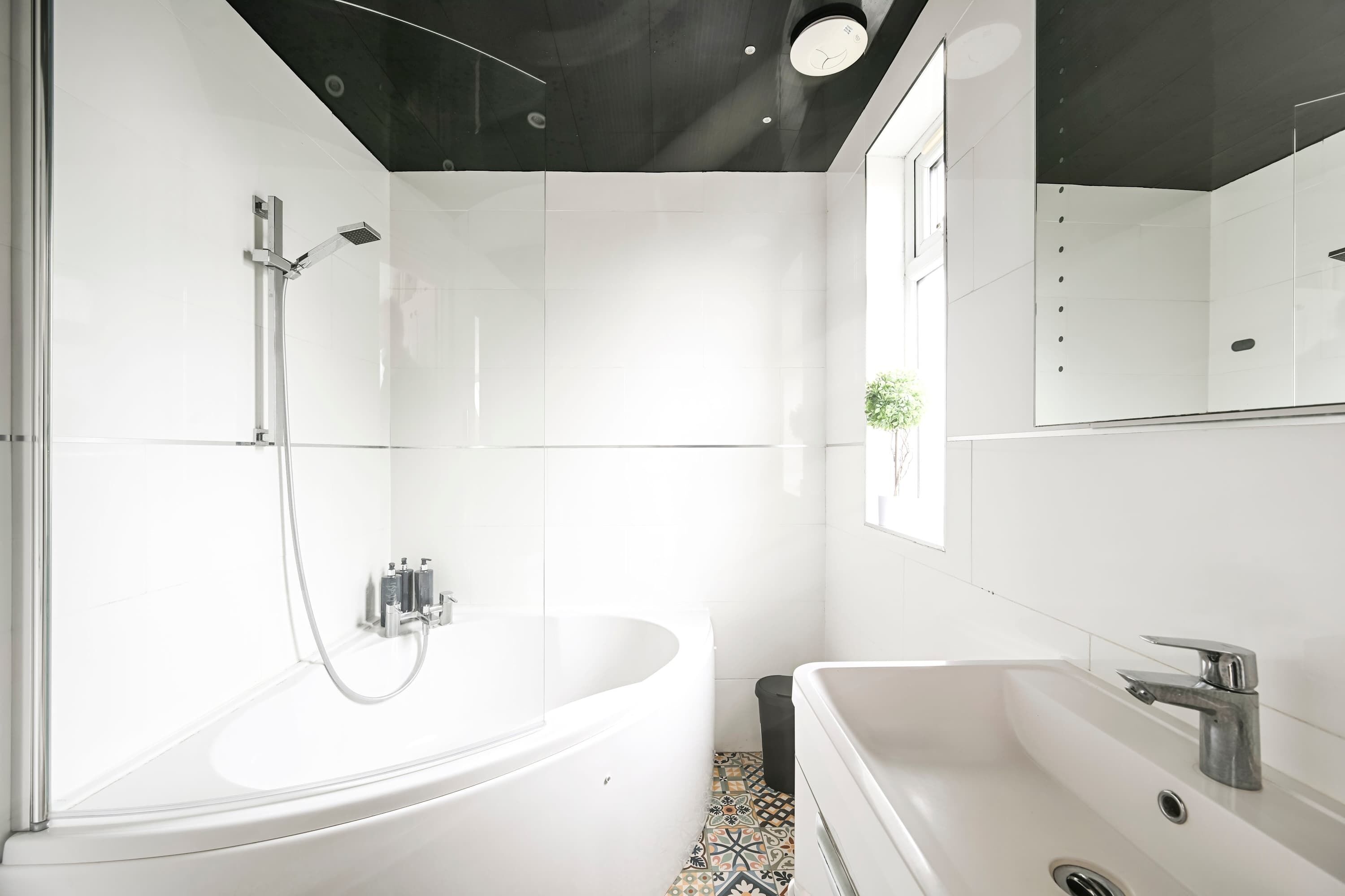 A modern bathroom with a freestanding bathtub, a separate sink, and a shower area.