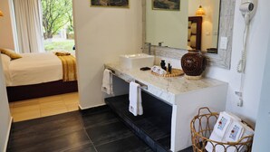 Ein Hotelzimmer mit Bett, einem Badezimmer mit Waschbecken, einem Spiegel und einem Fön.