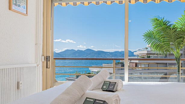 A hotel room with a balcony overlooking a coastal view, including mountains and the sea. - Elégant 2 pièces - accès mer direct vue splendide (Cannes)