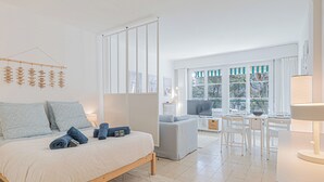 Quarto moderno com cama, mesas de cabeceira, escrivaninha e uma cadeira.