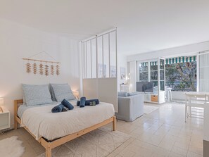 A modern bedroom with a bed, a TV, and a balcony. - Le Bleu Ciel - Studio Croisette idéal congrès (Cannes)