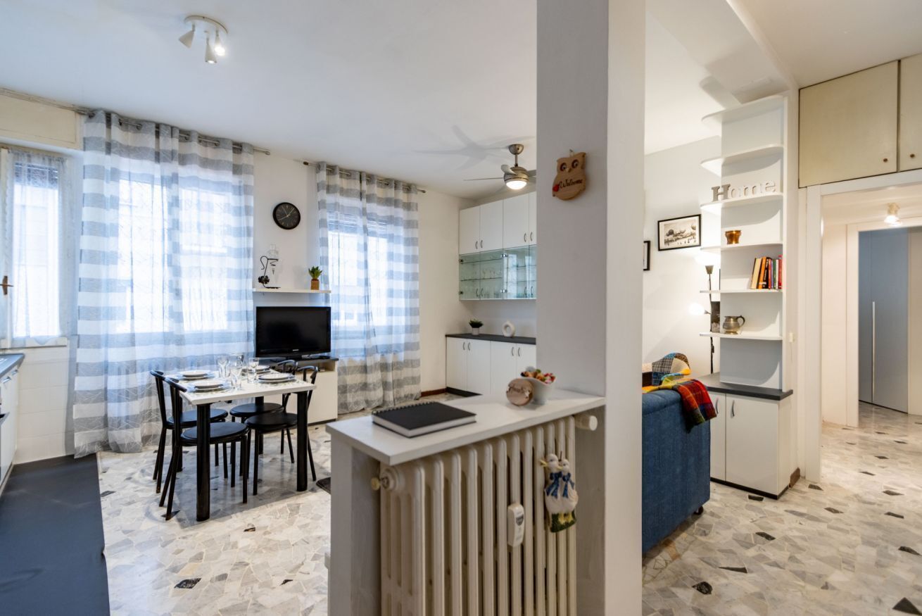 Un espace de vie compact comprenant un coin repas, une kitchenette et un petit coin salon.