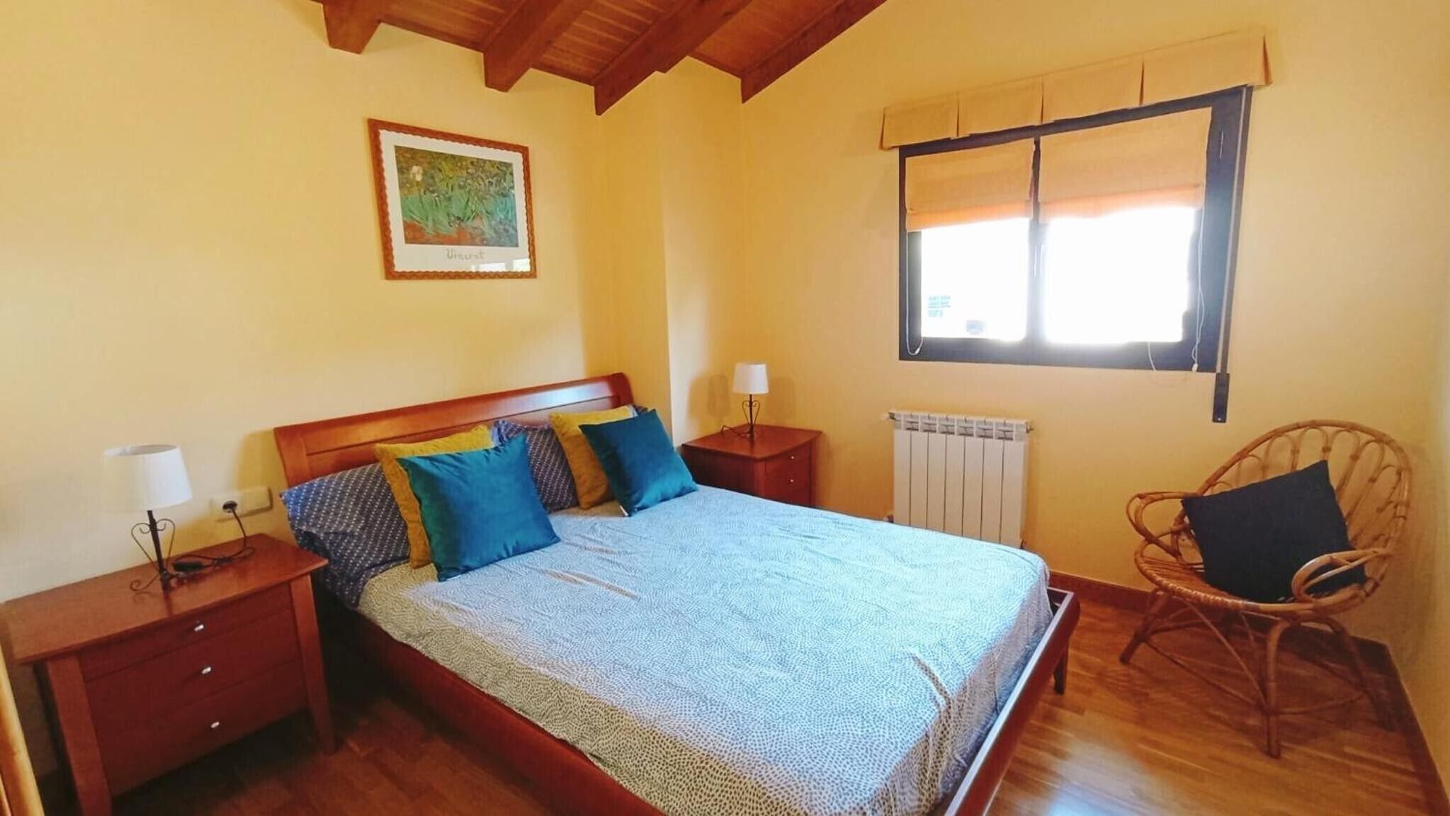 Una camera da letto con un letto, comodini, una sedia, una finestra e un termosifone.