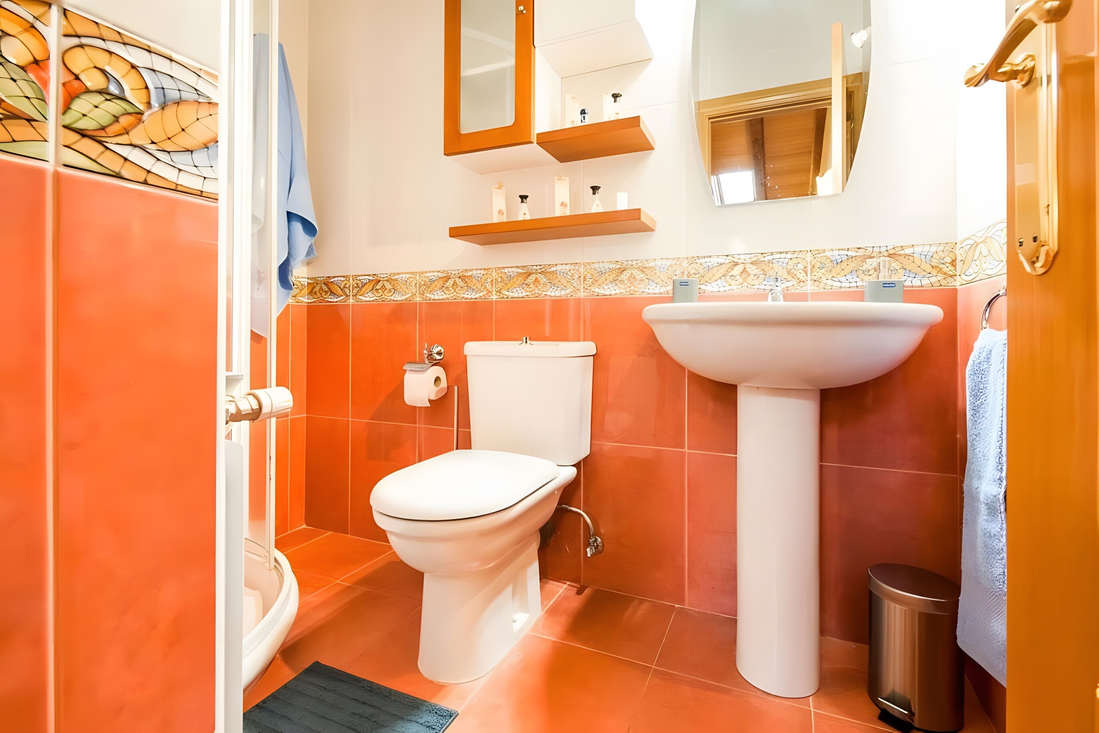 A bathroom with a toilet, sink, and shower.