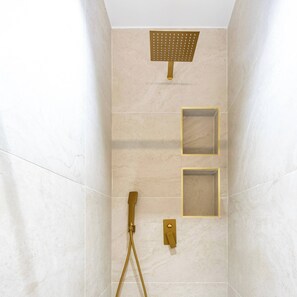 A shower with a gold showerhead, a handheld showerhead, and two square-shaped wall-mounted controls. - Spacious Paris Duplex for 4 Near Bastille (Paris)