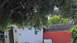 A wooden deck with four lounge chairs, a blue tarp, and a red wall. - House 50 m from portissol beach. All amenities within walking distance. (Sanary-sur-Mer)