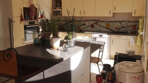 A modern kitchen with a central island, white cabinets, and a tiled backsplash. - House 50 m from portissol beach. All amenities within walking distance. (Sanary-sur-Mer)