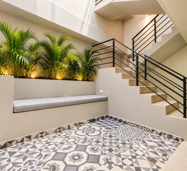 A modern interior with a staircase, a bench, and patterned flooring. - Stanza Hotel Sincelejo (Sincelejo)