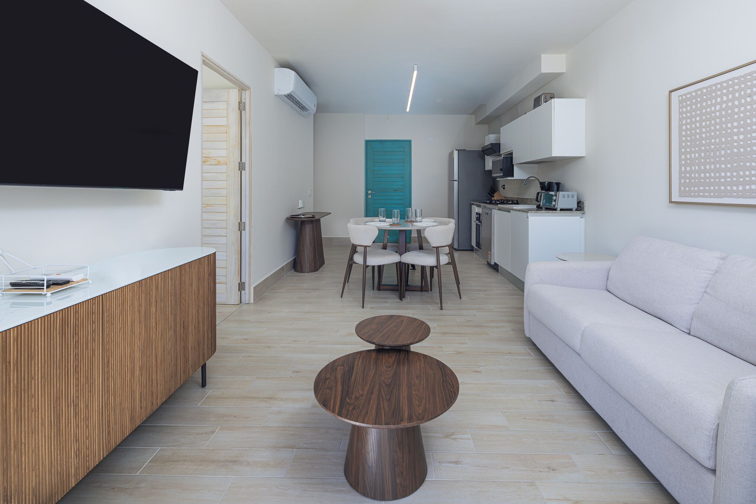 A modern kitchen with white cabinets, a built-in oven, and a microwave.