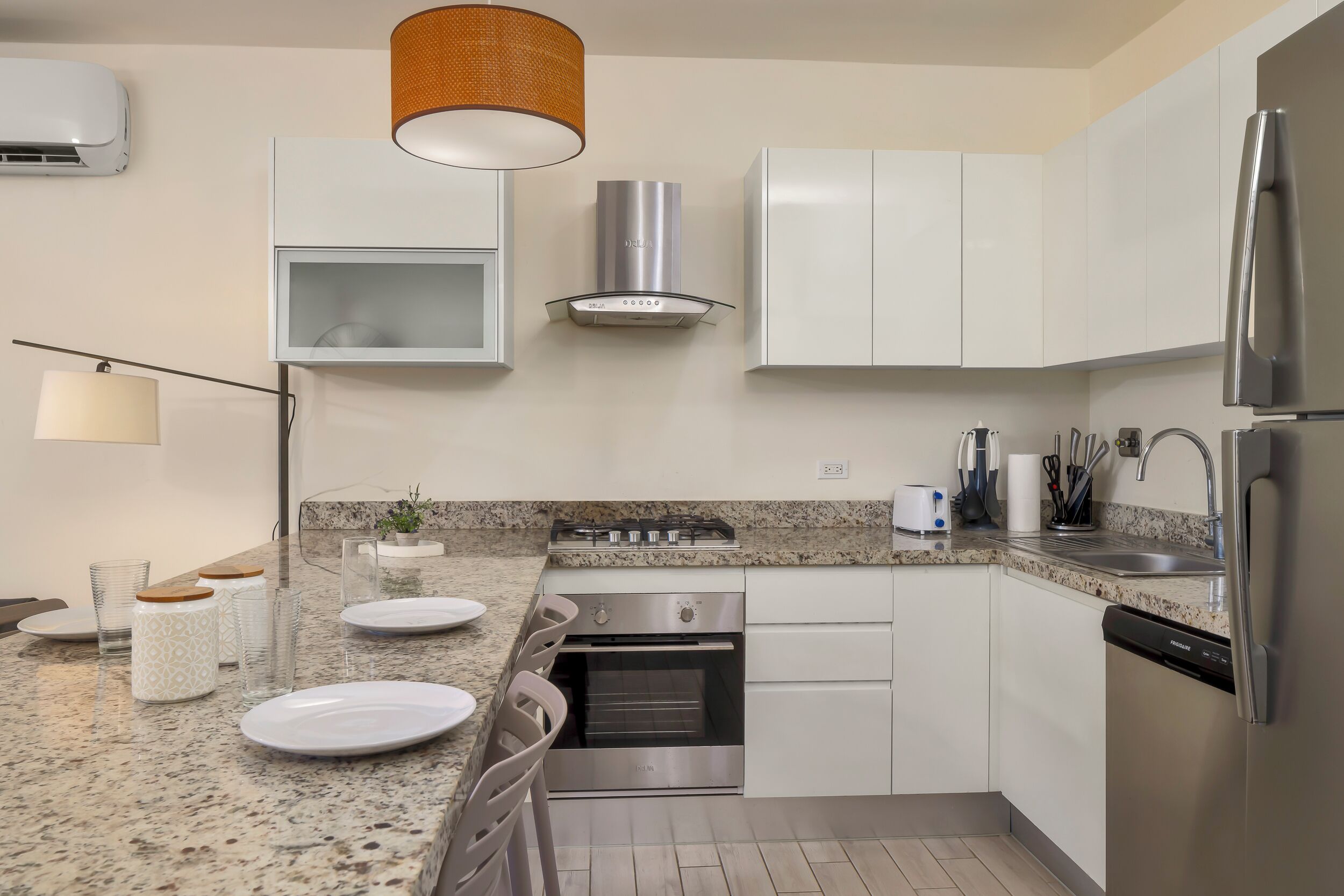 A modern kitchen with white cabinets, a stainless steel range, a built-in oven, and a dishwasher.