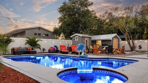 A backyard with a swimming pool, outdoor furniture, and a small house. - Family Luxury Escape Heated Pool, Spa, Mini Golf, Arcade (Largo)