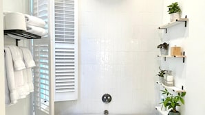 Un baño con una bañera independiente, un inodoro y un cabezal de ducha.