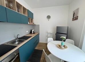Une cuisine de taille réduite, équipée d’un évier, d’une cuisinière et d’un petit réfrigérateur.