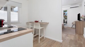 Une cuisine moderne dotée d’une cuisinière intégrée, de tabourets de bar blancs et d’un coin repas.