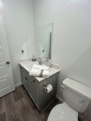Ein Badezimmer mit Waschbecken, Spiegel und Toilette.