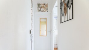 A hallway with a white door, a framed mirror, and a wall-mounted art piece. - Du côté de Giverny - Avec Parking Privé (Bennecourt)
