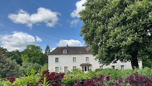 A stone building with a symmetrical facade, multiple windows, and a central entrance. - Le Gite de Caroline - Avec Parking Privé (Fère-en-Tardenois)