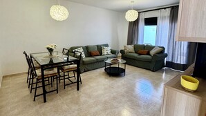 Un saló modern amb una taula de dinar, dos sofàs i una taula de centre.