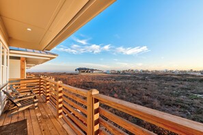 Une terrasse en bois offrant une vue sur un paysage côtier.