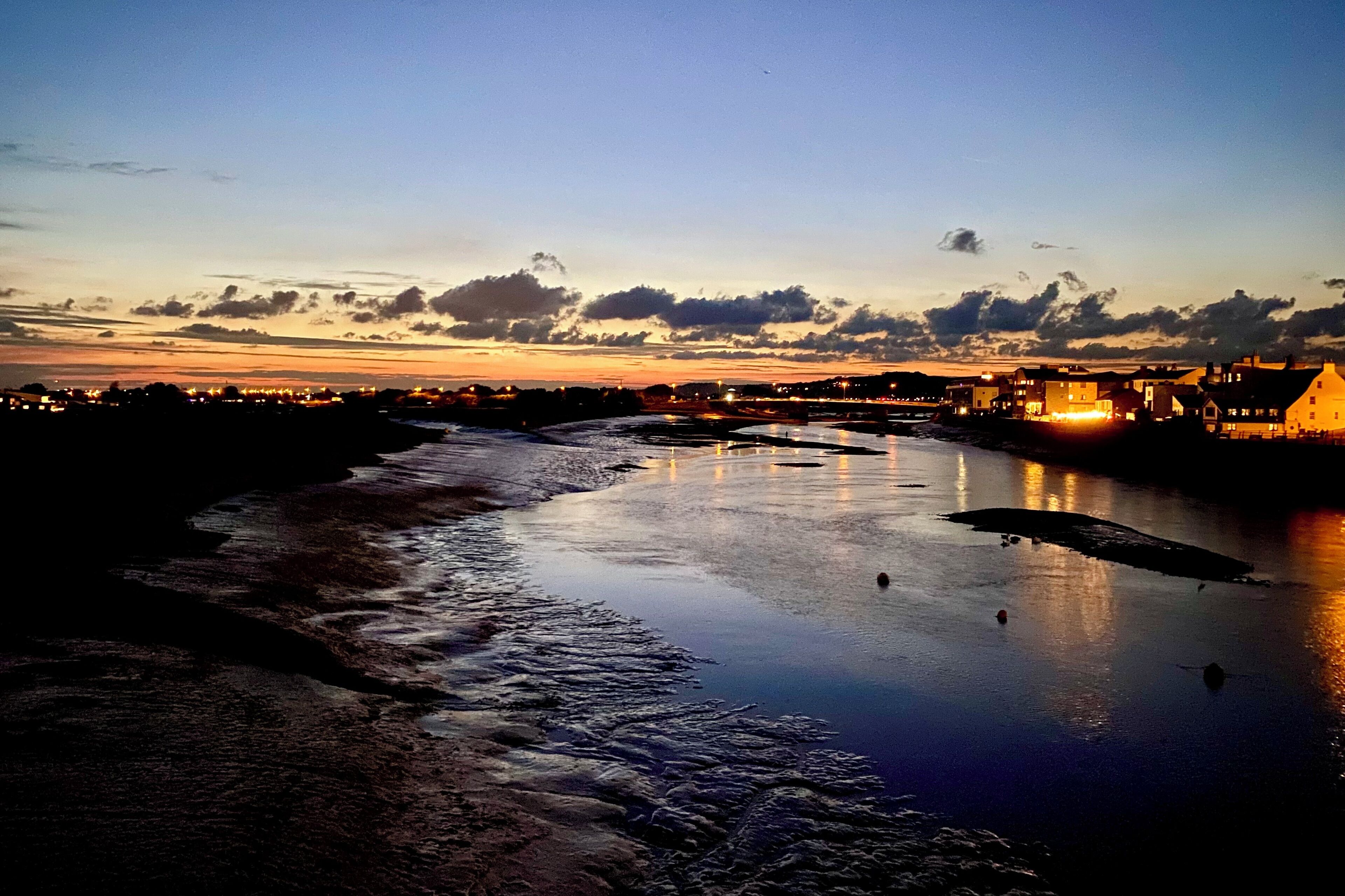 A river reflecting city lights at dusk.