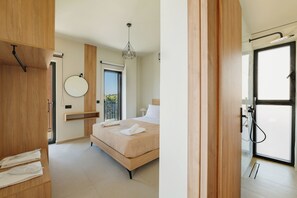 Ein modernes Schlafzimmer mit Bett, Nachttisch, Spiegel und einer Tür, die auf einen Balkon führt.